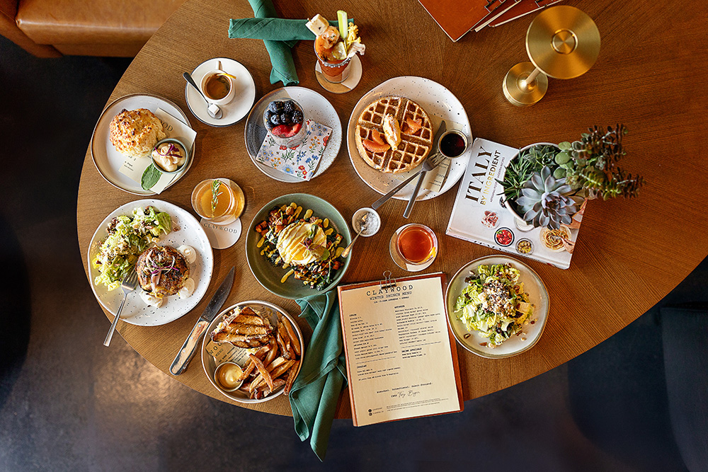 table with plates of brunch food spread across