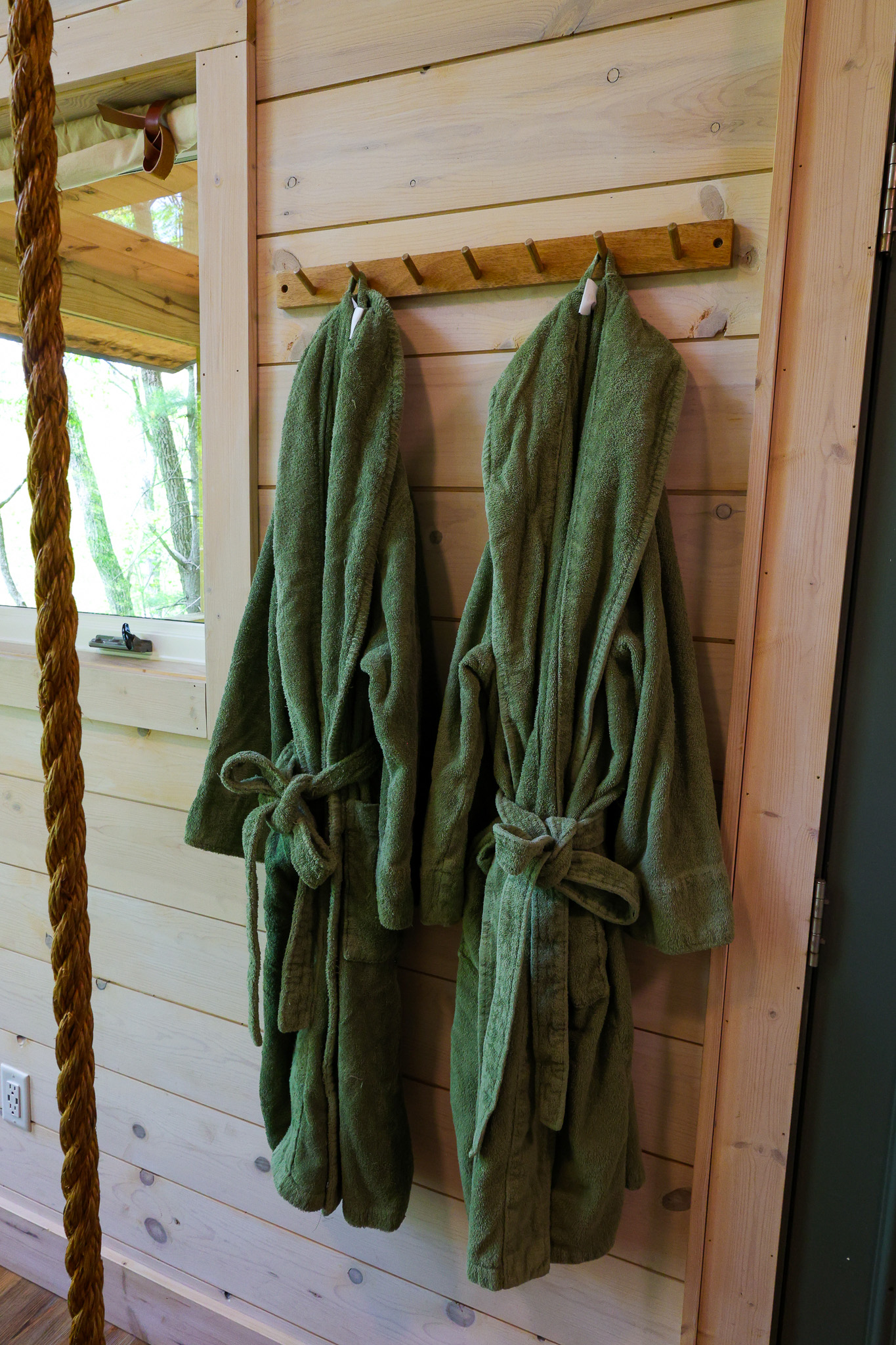 two green bath towels hanging up