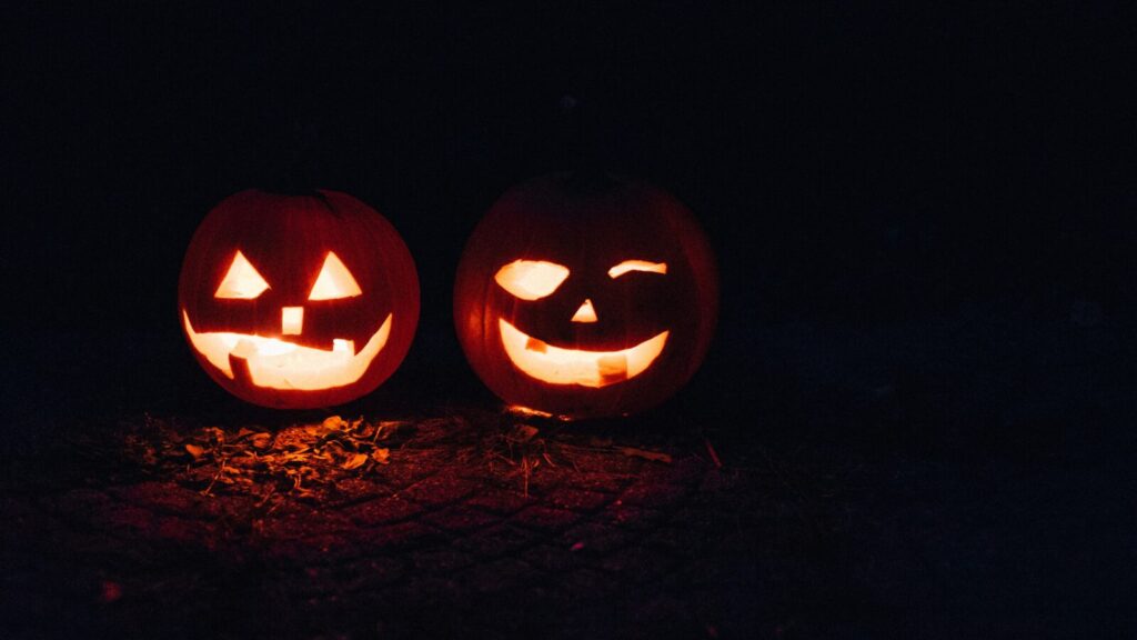 two pumpkins lit up n the dark