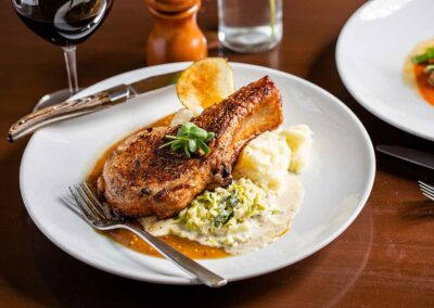 pork chop over mashed potatoes on a plate
