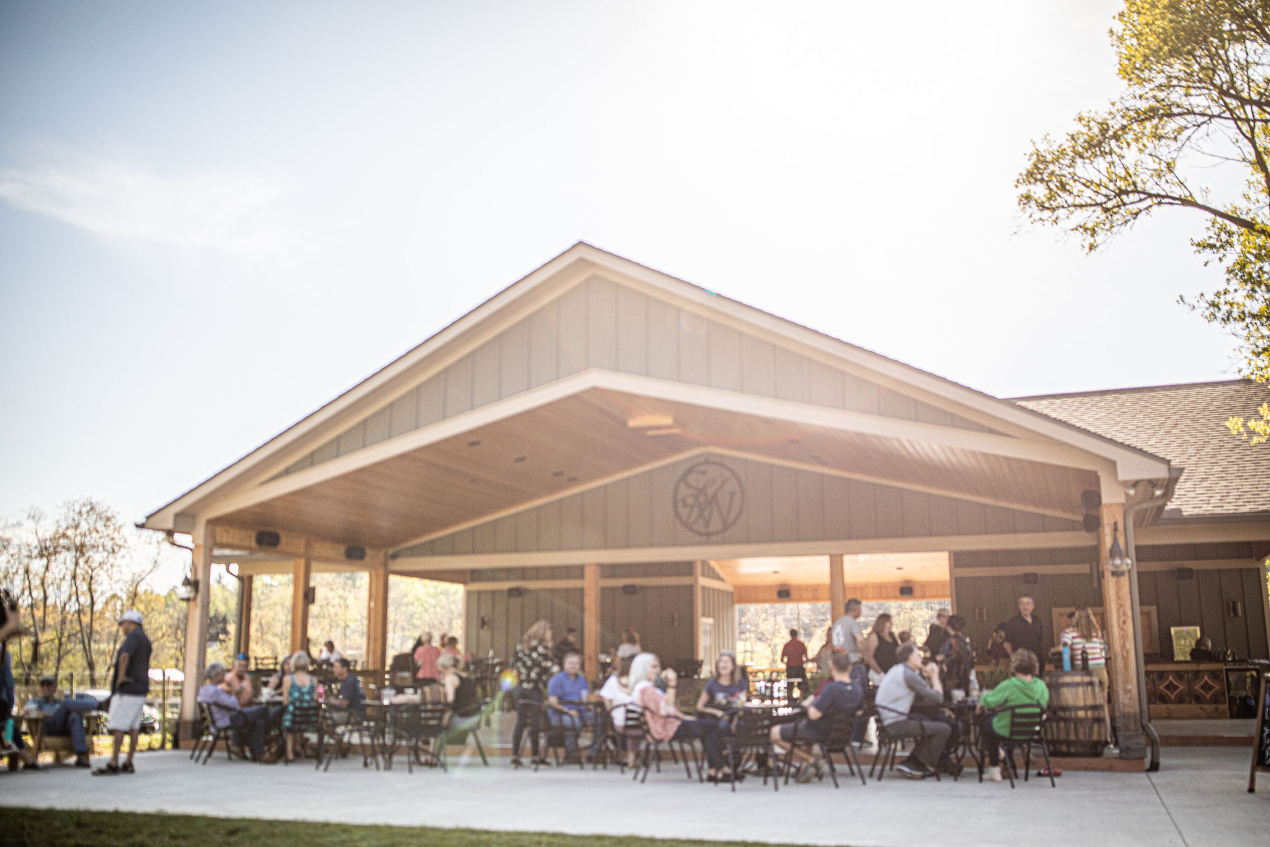 people sitting at an outdoor wine tasting pavilion