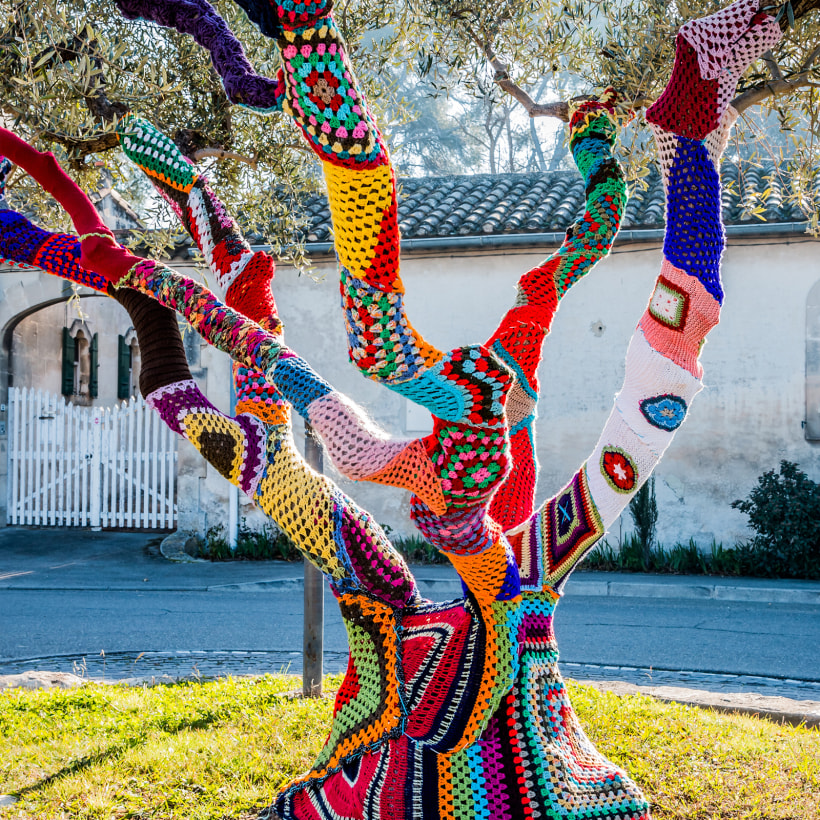 tree that is covered in crocheted items to be artistic